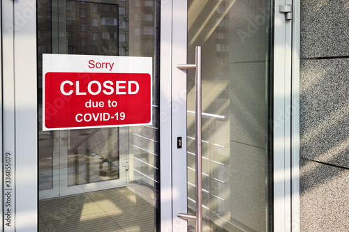 Business center closed due to COVID-19 coronavirus, sign with sorry in door window. Stores, restaurants, offices, other public places temporarily closed