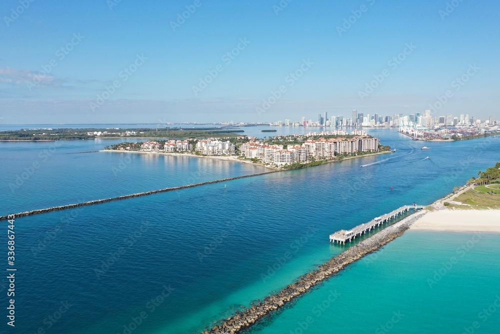 Government Cut jetties and Fisher Island on clear sunny morning with City of Miami skyline in background.