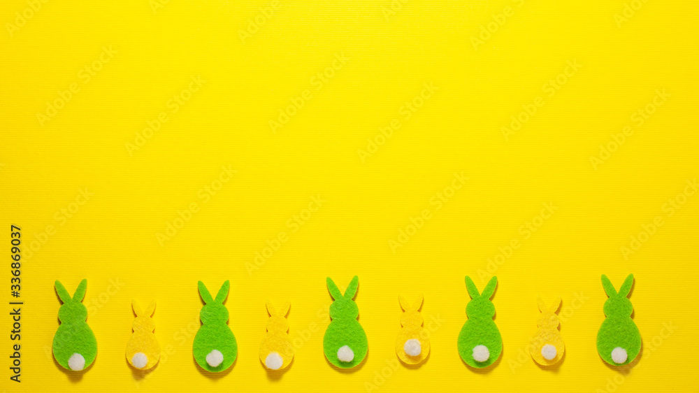 Yellow and gree velvet bunnies on yellow background flat lay