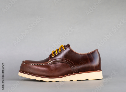 Men fashion brown shoe leather over gray background.