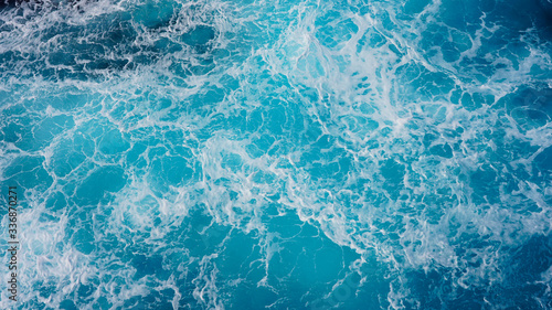Sea blue water surface background, foam streaks on natural ocean background. Aerial view of the ocean