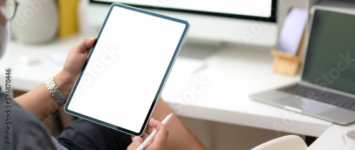 Cropped shot of male entrepreneur reading informations on vertical blank screen tablet