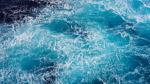 Sea blue water surface background  foam streaks on natural ocean background. Aerial view of the ocean