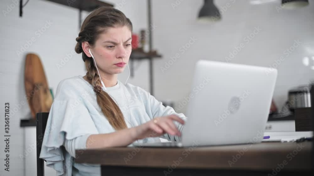The girl works at the computer at home. Homework. Tired worker in front of a laptop. Business woman remotely negotiates. The girl works at the computer at home. Homework. Tired worker in front of a laptop. Business woman remotely negotiates.