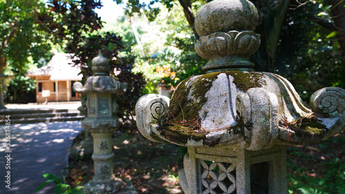 ancient Japanese statues, lanterns on the road through the jungle to a Buddhist temple. creepers and jungle over the road to a Japanese traditional religious temple. ancient temple on island Okinawa