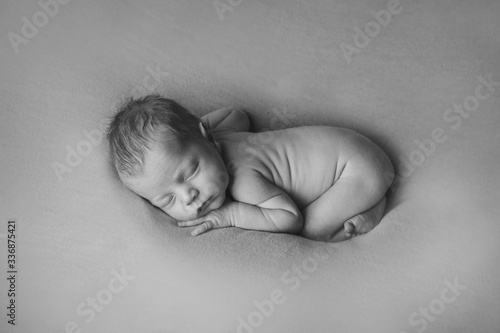 naked Newborn baby lying. Imitation of baby in womb. beautiful little girl sleeping on her back. manifestation of love. Health care concept, parenthood, children's Day, medicine, IVF