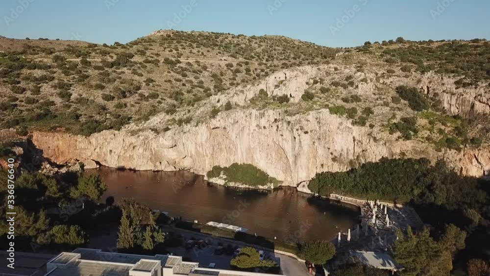 Lake & mountain by drone rising up shot in a sunny day with some buildings. Lake & mountain by drone rising up shot in a sunny day with some buildings.