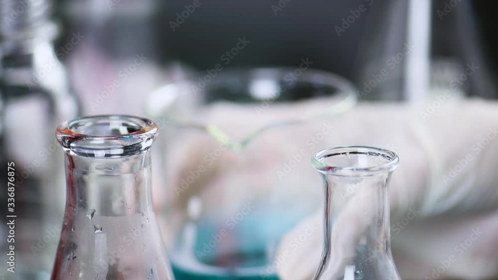 Dropper Function scientist hand holding a medical dropper filled with blue solution ...