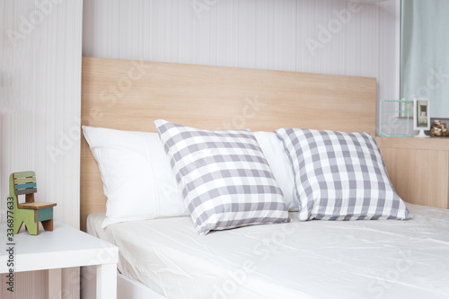 Luxury pillows on white bed in bedroom