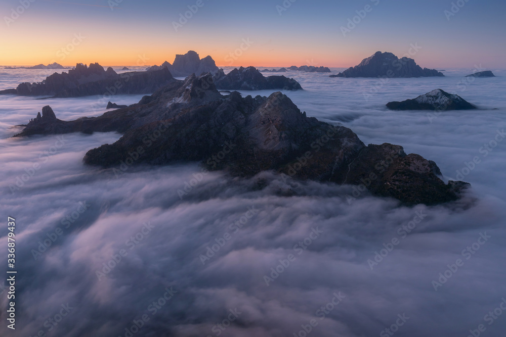 Obraz premium View of famous Dolomites mountain peaks glowing in beautiful golden morning light at sunrise in summer, South Tyrol,Italy dramatic view of dolomites mountains above the clouds Famous best alpine place