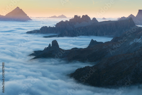 View of famous Dolomites mountain peaks glowing in beautiful golden morning light at sunrise in summer, South Tyrol,Italy dramatic view of dolomites mountains above the clouds Famous best alpine place