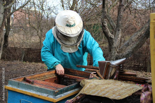 Beehive Spring Management. Beekeeper inspecting bee hive and prepares apiary for summer season. The spring works in the apiary. The start of beekeeping season. Frames of a bee hive. 
