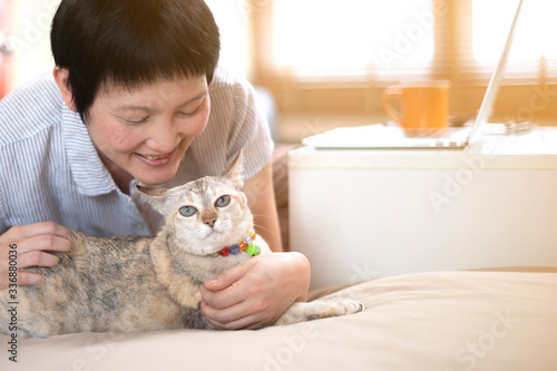 Asian woman work at home online with computer drink coffee and together with cat happiness concept