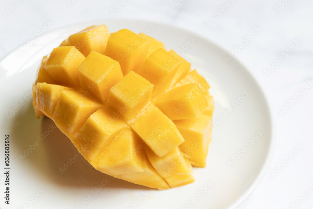 Mango slice with cubes on dish; ready to eat. Tropical fruits.