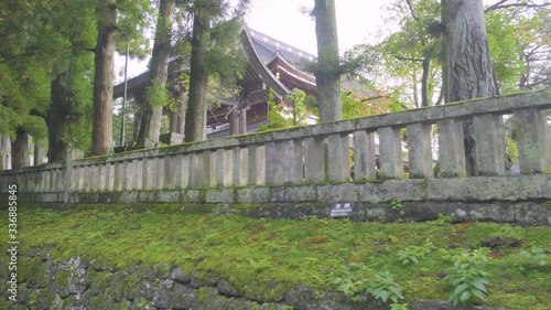 Camera track left along stone fence outside Nikkozan Rinnoji Temple along walkway leading to Toshogu Shrine in Nikko, Japan