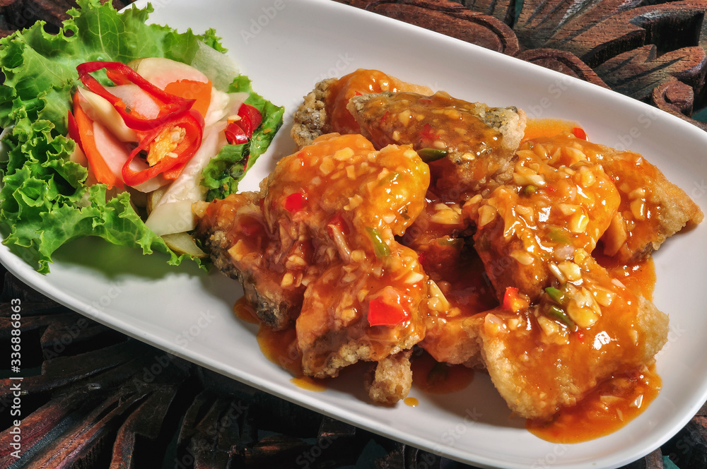 Fried fish topped 3 flavors chili sauce on a white plate Fried fish topped 3 flavors chili sauce on a white plate