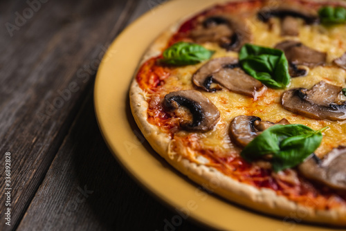 Freshly making pizza with mushrooms served on the rustic background. Selective focus. Shallow depth of field.