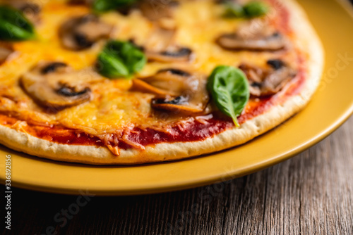Freshly making pizza with mushrooms served on the rustic background. Selective focus. Shallow depth of field.