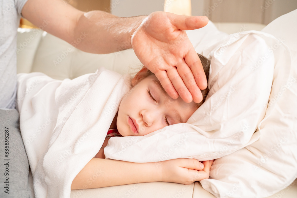 daddy hand touches forehead of patient daughter. daddy hand touches forehead of patient daughter.