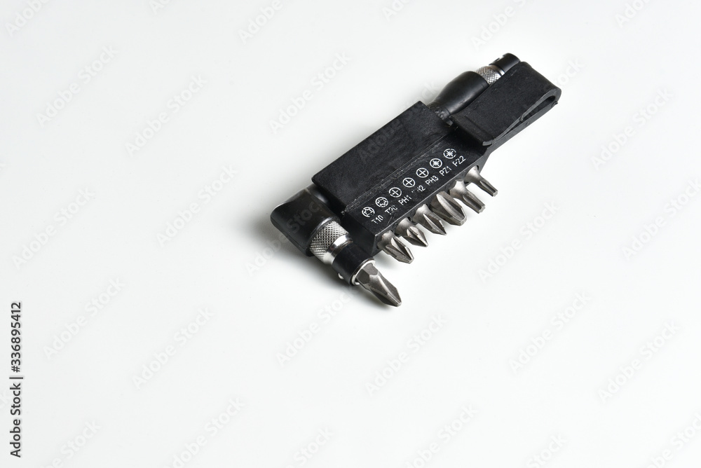 Angle L-shaped screwdriver with bit set and belt clip isolated on white background. Close up Angle L-shaped screwdriver with bit set and belt clip isolated on white background. Close up