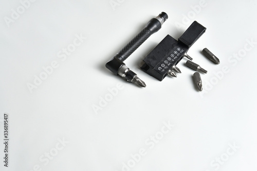 Angle L-shaped screwdriver with bit set and belt clip isolated on white background. Close up