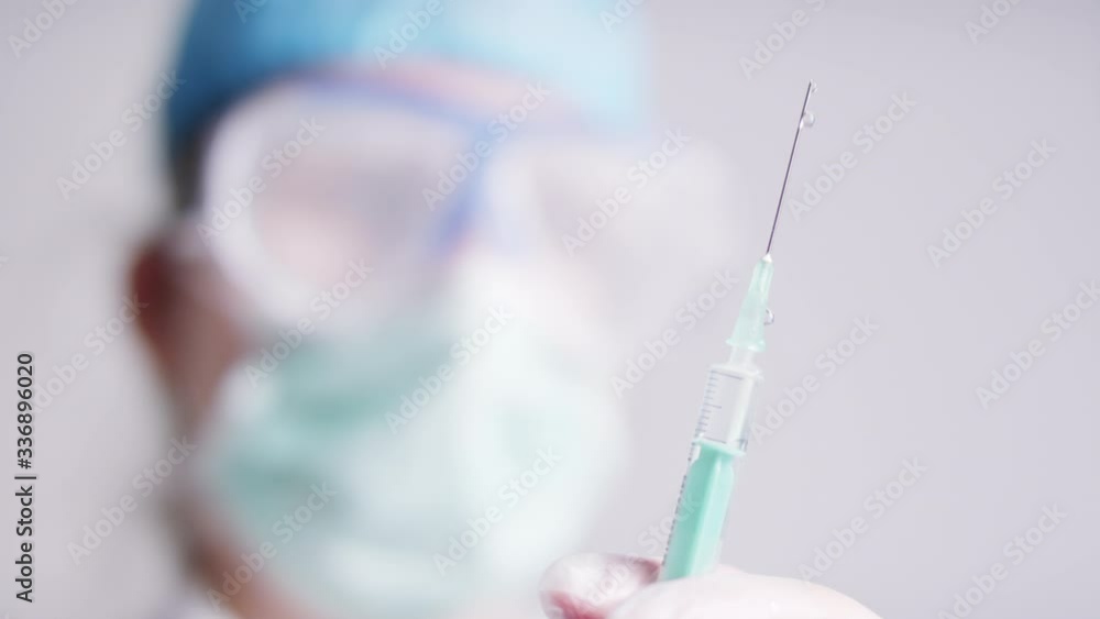 doctor with googles, medical mask prepares vaccine. Holding syringe with nCoV Coronavirus vaccine for 2019-nCoV COVID virus. doctor with googles, medical mask prepares vaccine. Holding syringe with nCoV Coronavirus vaccine for 2019-nCoV COVID virus.