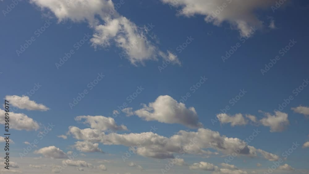 White clouds move against blue daytime sky White clouds move against blue daytime sky