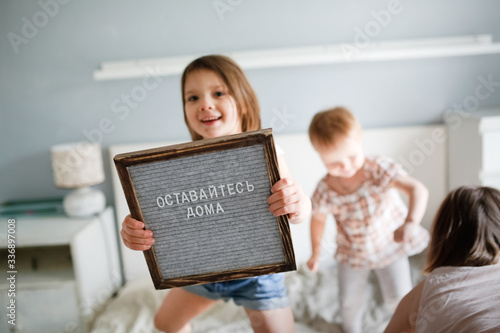 children are jumping on bed, Russian is Stay home