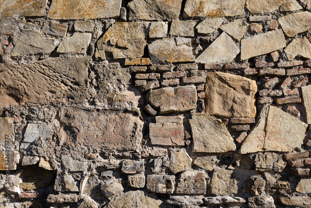 stones of different sizes lie on each other. The wall is made of stone. stones of different sizes lie on each other. The wall is made of stone.