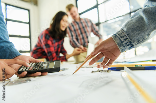 Принти на полотні One of the architects or a group of engineers is meeting, working, and pointing to the drawings in the office to talk