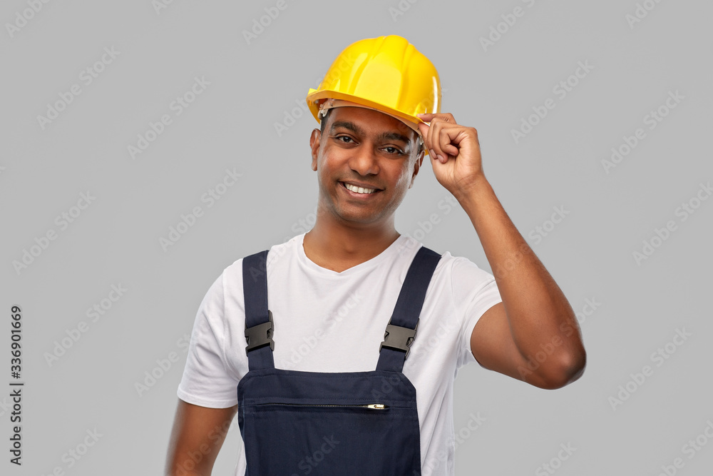 profession, construction and building - happy smiling indian worker or builder in helmet over grey background profession, construction and building - happy smiling indian worker or builder in helmet over grey background