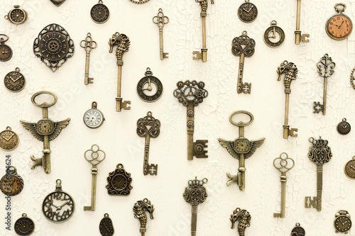 Image of old antique keys and clocks over wooden background. Top view, flat lay