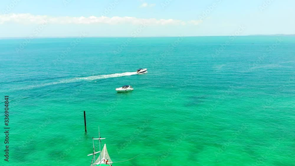 Beautiful Aerial shot of turquoise water, sailboats and one motor boat gliding into the horizon at Itaparica Island, Bahia, Brazil Beautiful Aerial shot of turquoise water, sailboats and one motor boat gliding into the horizon at Itaparica Island, Bahia, Brazil