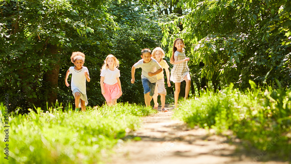 Gruppe glücklicher Kinder läuft über Wiese Stock Photo Adobe Stock