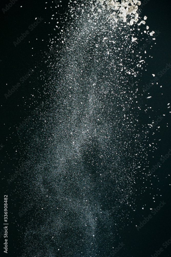 Obraz premium Wonderful pattern of white powder of light snow and flour explodes on black background