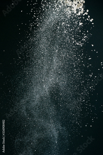 Wonderful pattern of white powder of light snow and flour explodes on black background