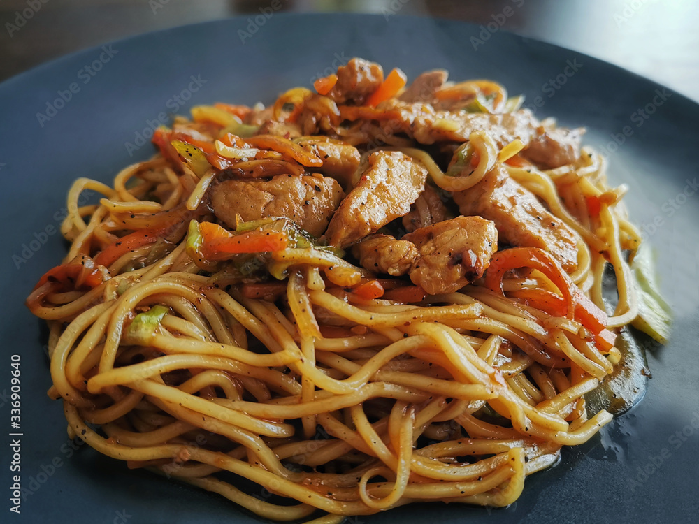 Pork chow mein on a black plate. Selective focus. Pork chow mein on a black plate. Selective focus.
