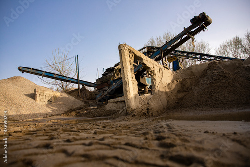 Machine sorting sand and gravel. Excavator and conveyer at the quarry