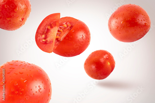 Fresh flying tomatoes on a white background with drops. Tomatoes with full depth of coldness
