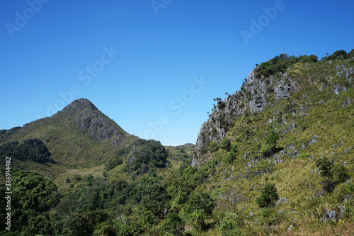 Natural landscape of rocky green mountain range view with clear blue sky