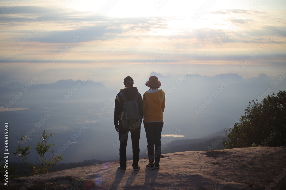 Men and women standing on the cliff, waiting for sunrise in Phu Kradueng National Park, Loei, Thailand 