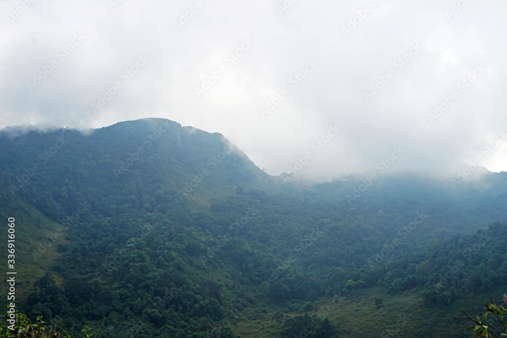 Natural landscape of green mountain range with cloudy blue sky Natural landscape of green mountain range with cloudy blue sky