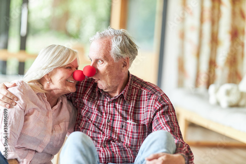 Senior couple is kidding around with clown nose photo