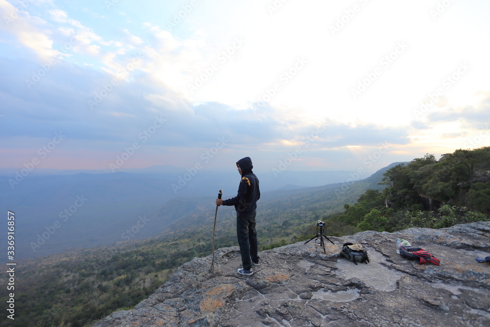 Man standing on the cliff, waiting for sunset pictures.