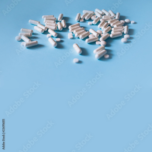 White medical pills on blue background. 
