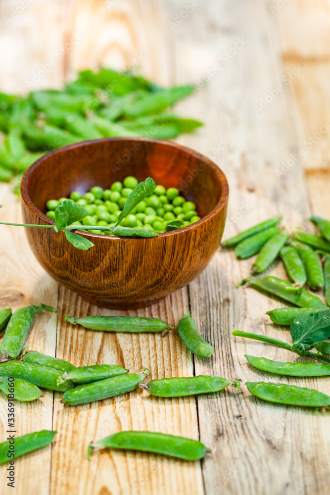 closeup green peas in brown dish, on wooden table. closeup green peas in brown dish, on wooden table.