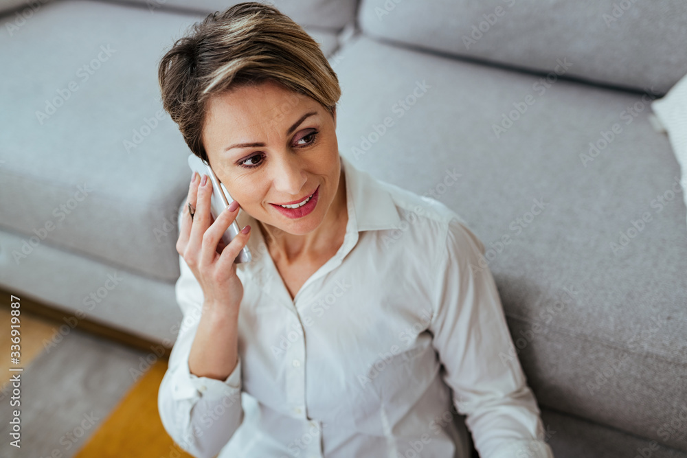 Happy businesswoman talking on mobile phone at home. Happy businesswoman talking on mobile phone at home.