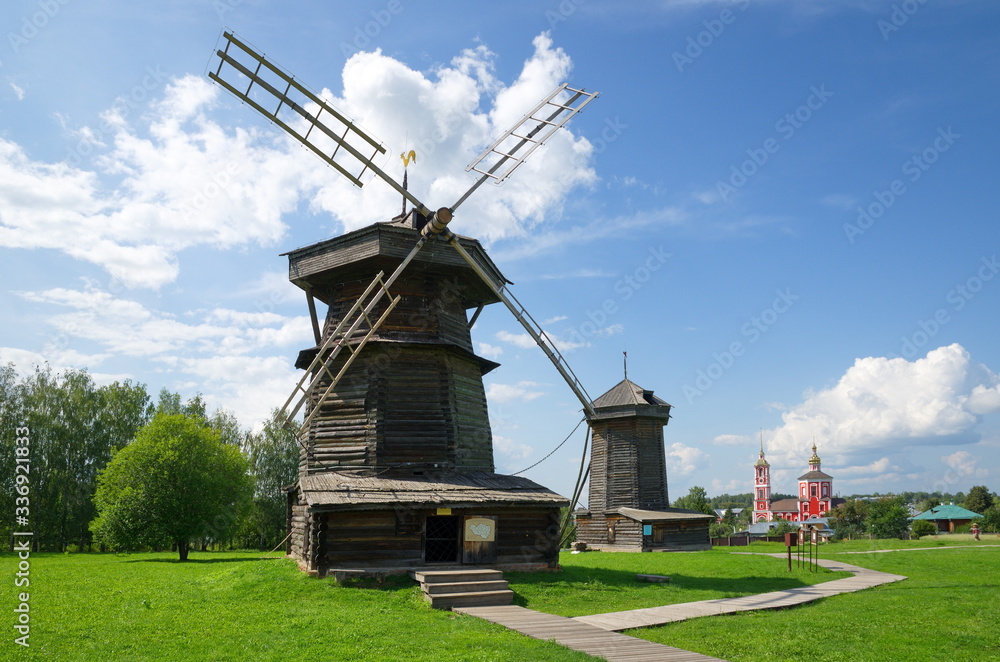 Suzdal, Russia - July 26, 2019: Museum of wooden architecture and peasant life. Windmills from the village of Moshok Sudogodsky district (18th century) and the Church of Boris and Gleb 