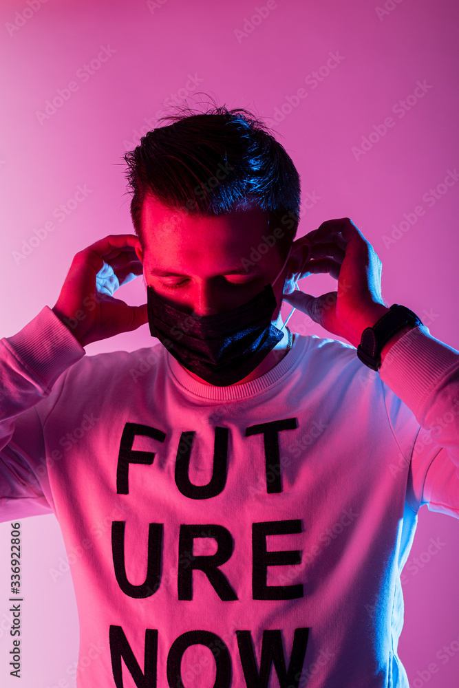 Young man put on a mask in neon light Young man put on a mask in neon light