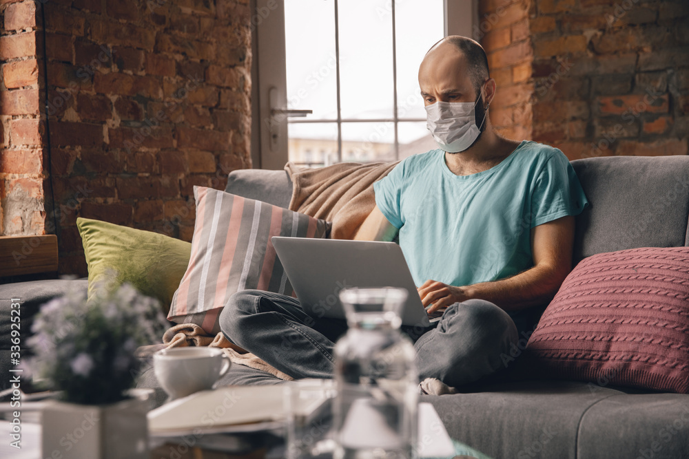 Typing text. Young man doing yoga at home while being quarantine and freelance online working. Remote office, isolated. Concept of healthy lifestyle, wellness, being safe while coronavirus pandemic. Typing text. Young man doing yoga at home while being quarantine and freelance online working. Remote office, isolated. Concept of healthy lifestyle, wellness, being safe while coronavirus pandemic.